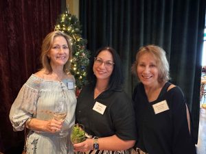 Three women standing in front of a Christmas tree